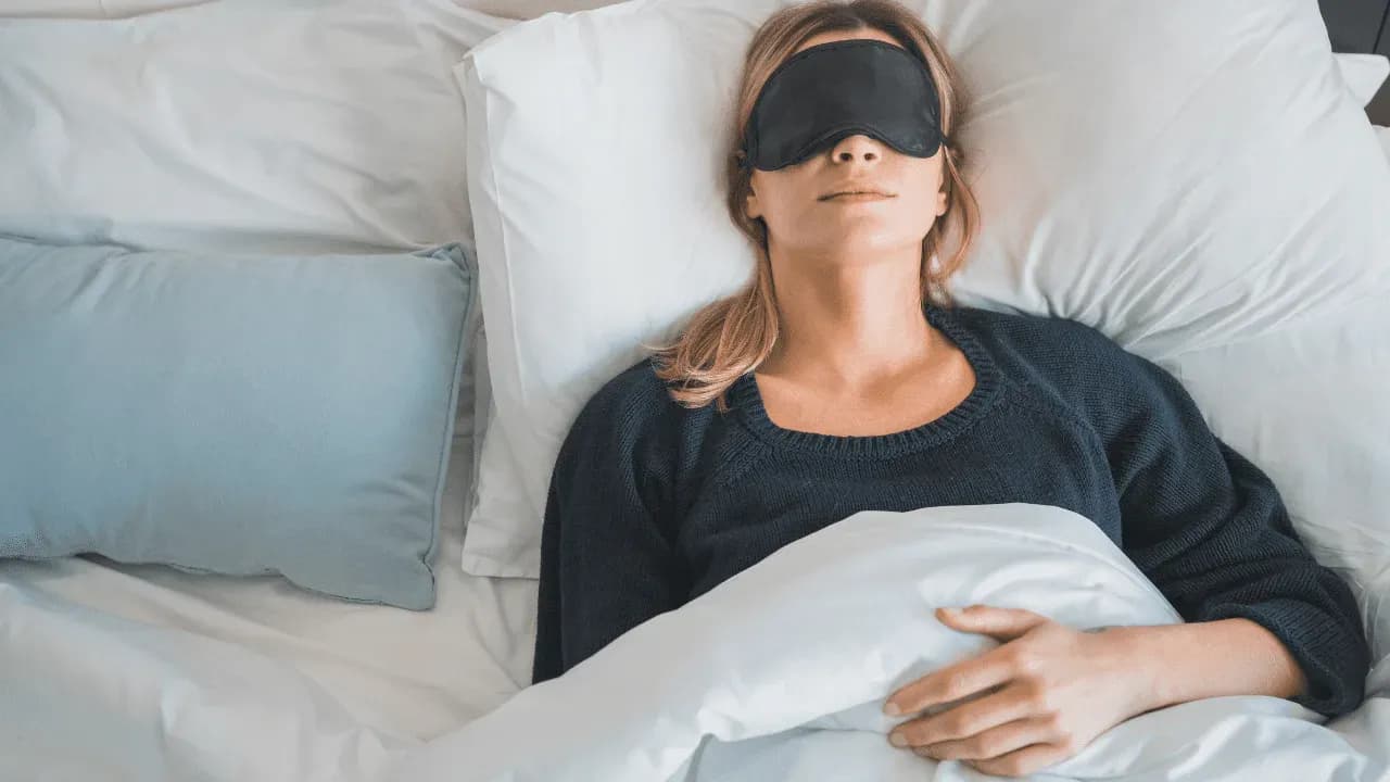 A woman sleeping with an eye mask